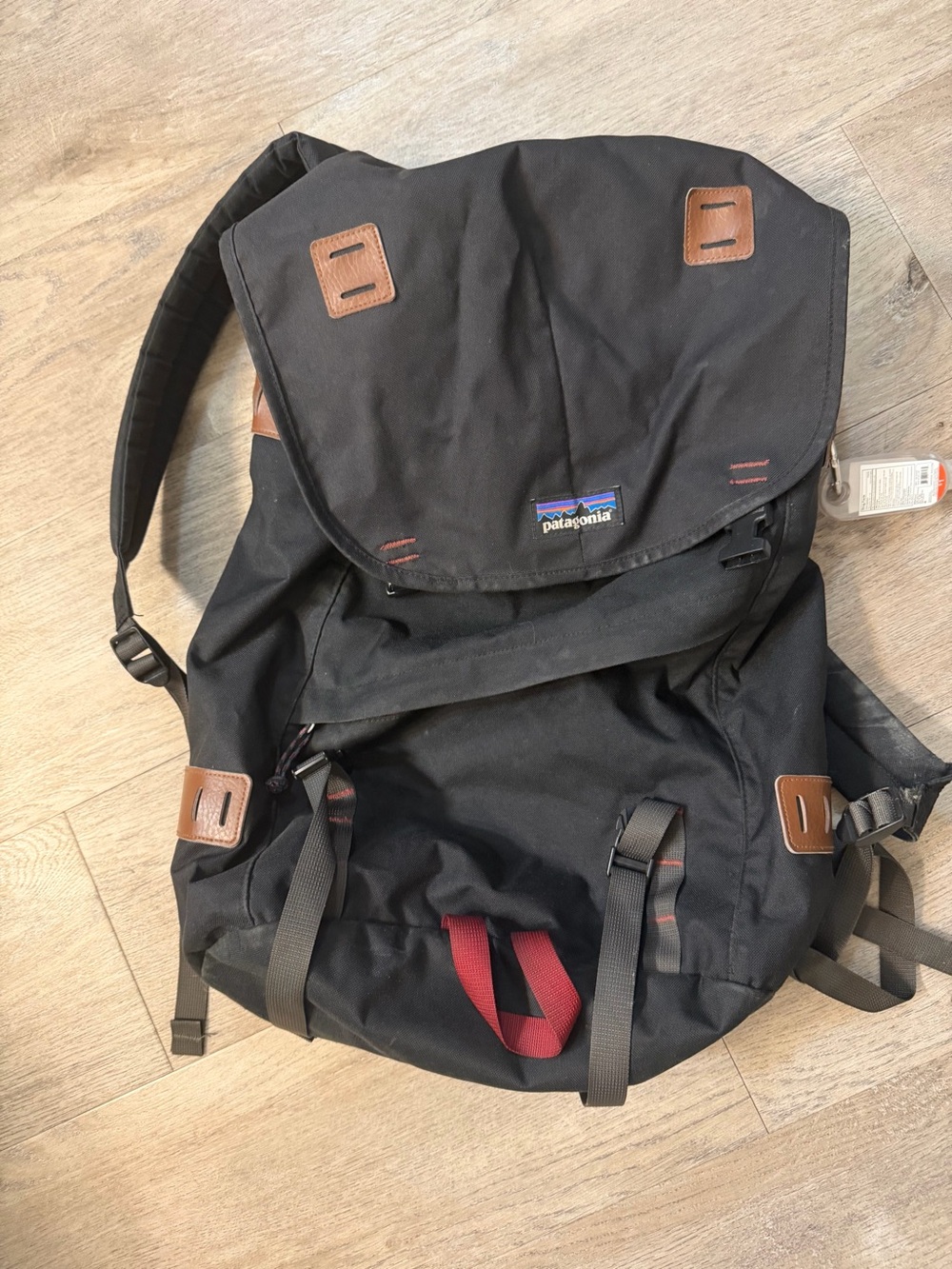 Patagonia Black Backpack with Brown Leather Accents and Red Carry Loop
